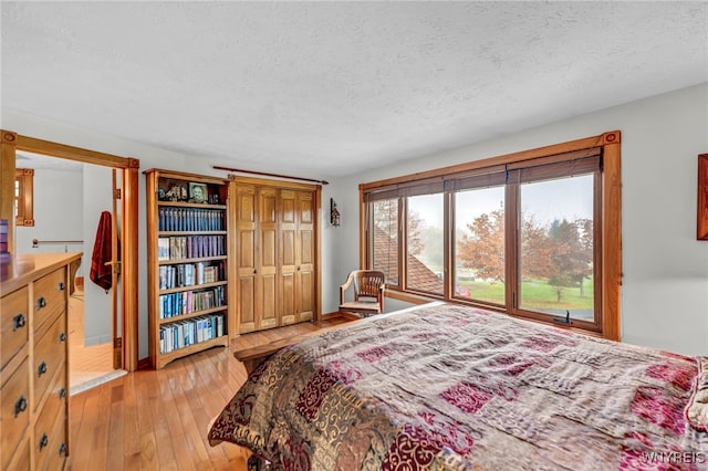 bedroom featuring light hardwood / wood-style flooring and a textured ceiling