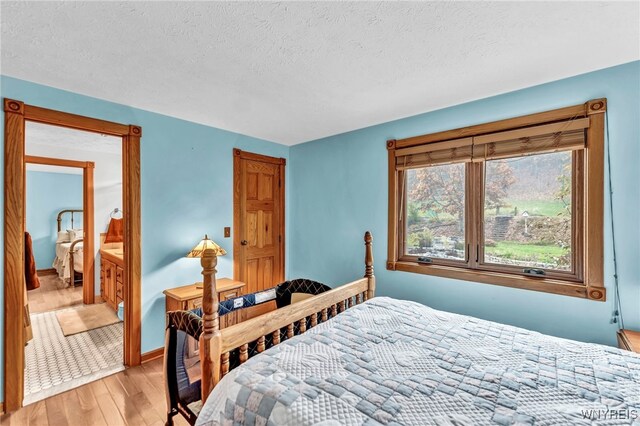 bedroom with light hardwood / wood-style flooring and a textured ceiling