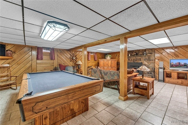 playroom featuring pool table, light tile patterned floors, wood walls, a fireplace, and a drop ceiling