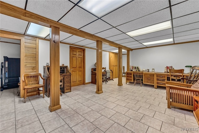 basement with a drop ceiling and light tile patterned floors