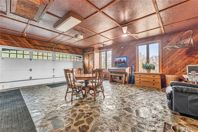 dining space featuring wood walls and ceiling fan