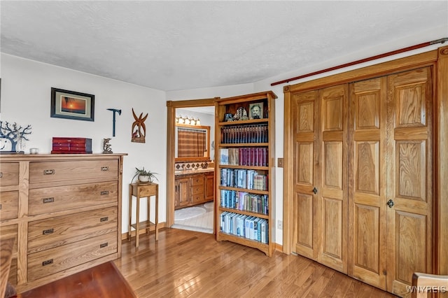 misc room with a textured ceiling and light hardwood / wood-style floors