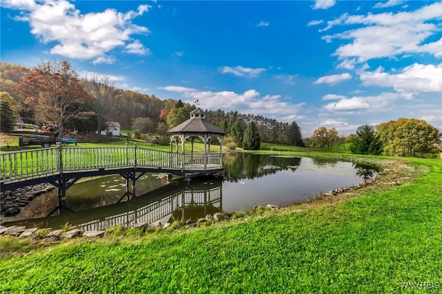 view of dock with a gazebo, a yard, and a water view