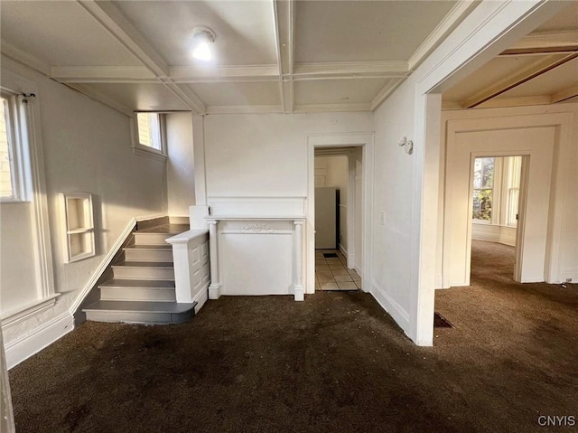 interior space featuring beamed ceiling, dark carpet, and coffered ceiling