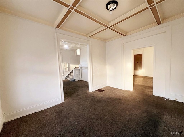 empty room featuring dark colored carpet, beam ceiling, and coffered ceiling