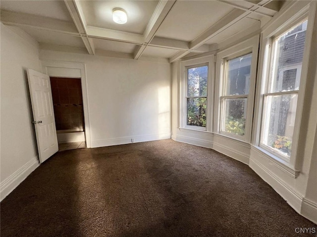 unfurnished room featuring beamed ceiling, dark carpet, and coffered ceiling