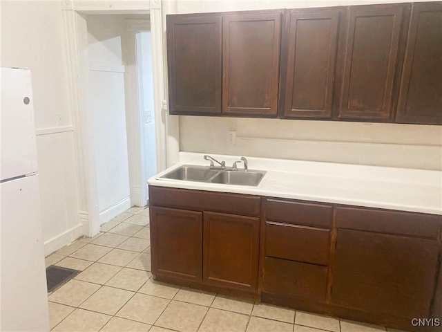 kitchen with sink, white fridge, and light tile patterned floors