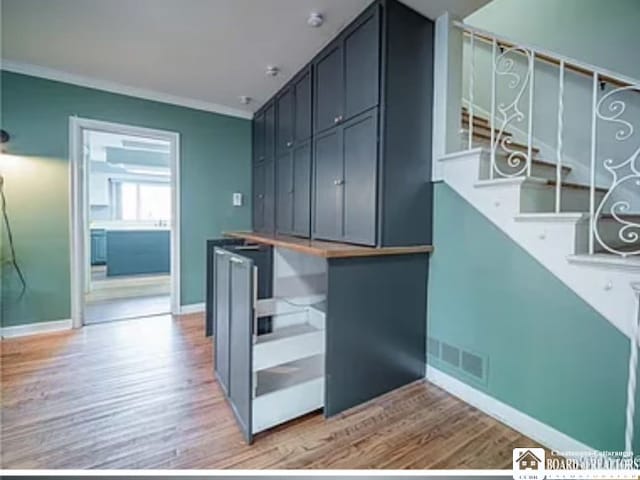 interior space with light wood-type flooring and ornamental molding