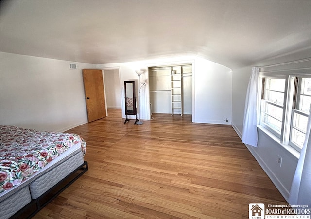 bedroom featuring lofted ceiling and light hardwood / wood-style flooring