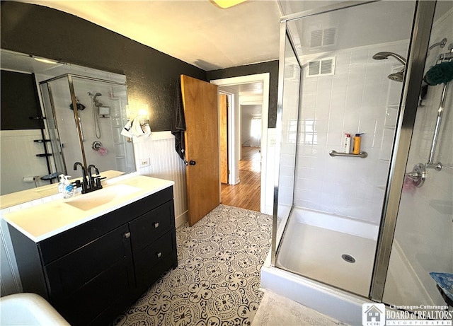 bathroom with an enclosed shower, vanity, and hardwood / wood-style floors