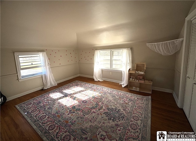 bonus room with dark wood-type flooring and vaulted ceiling