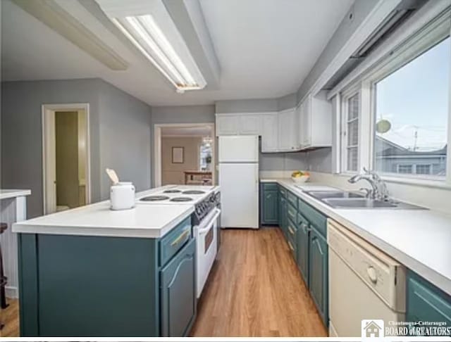 kitchen with light hardwood / wood-style floors, sink, white appliances, blue cabinetry, and white cabinets