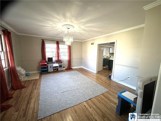 interior space featuring hardwood / wood-style floors, a notable chandelier, and ornamental molding