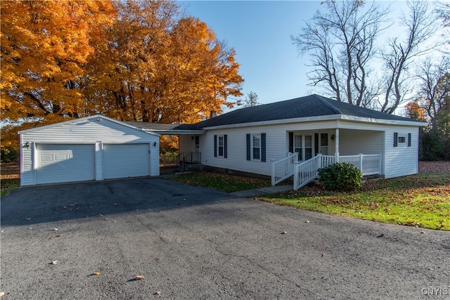 single story home with a porch, an outbuilding, and a garage