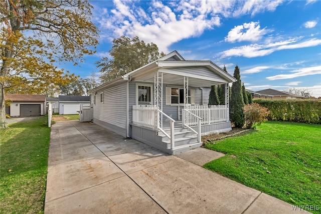 bungalow-style home featuring covered porch, a front yard, an outbuilding, and a garage