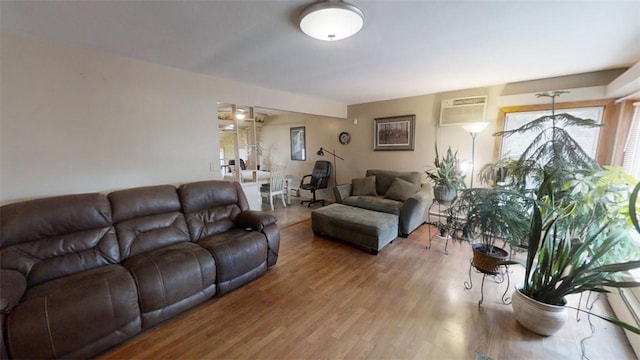 living room featuring a wall mounted air conditioner and hardwood / wood-style floors