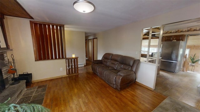 living room with a baseboard heating unit and wood-type flooring