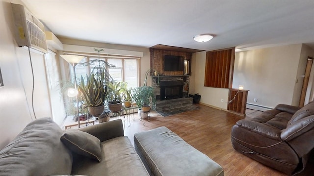 living room featuring a baseboard heating unit, hardwood / wood-style flooring, and a fireplace