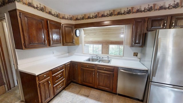 kitchen with stainless steel appliances, dark brown cabinetry, and sink