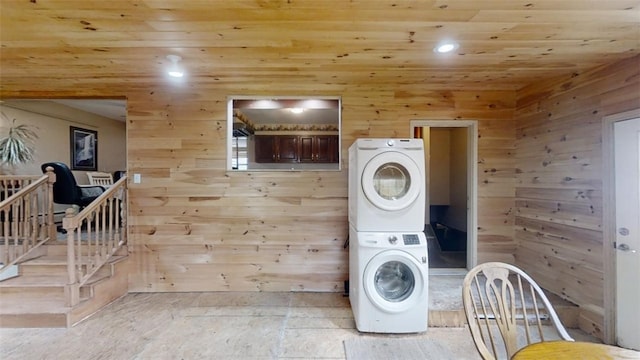 laundry area with stacked washer / drying machine, wooden ceiling, and wooden walls