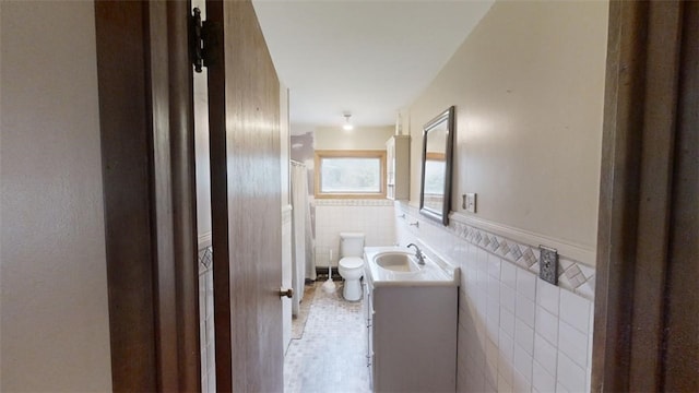 bathroom featuring tile walls, vanity, toilet, and tile patterned flooring