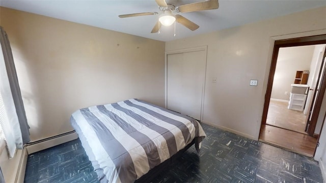 bedroom featuring a closet, dark parquet floors, baseboard heating, and ceiling fan