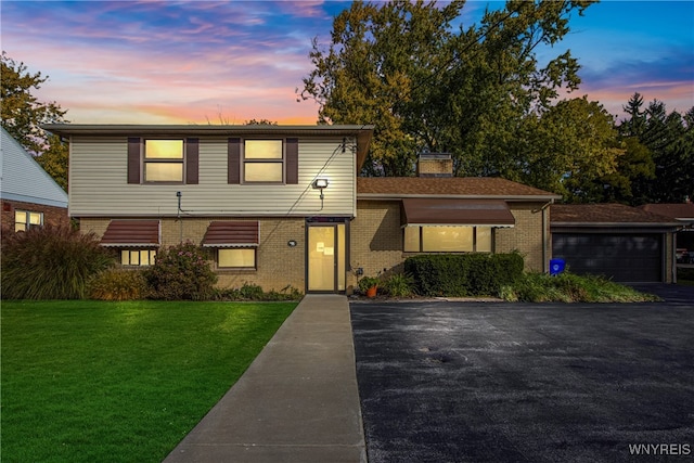 view of front of property featuring a garage and a lawn