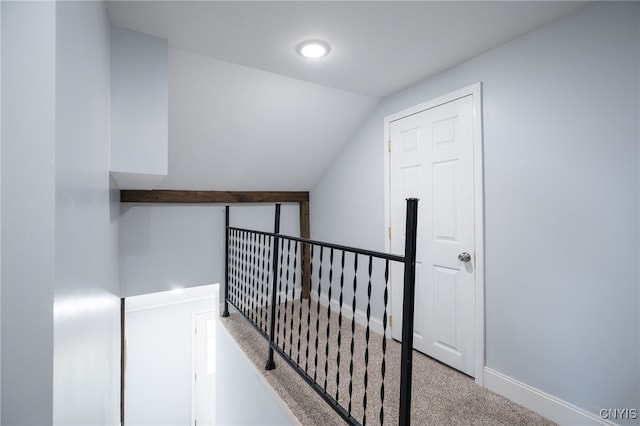 corridor with lofted ceiling and light colored carpet