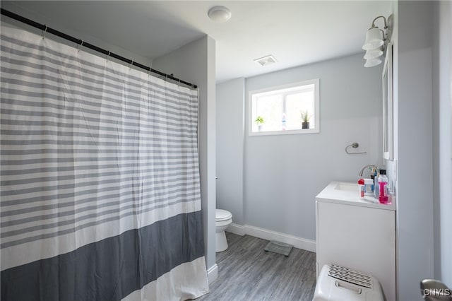 bathroom with toilet, walk in shower, vanity, and wood-type flooring