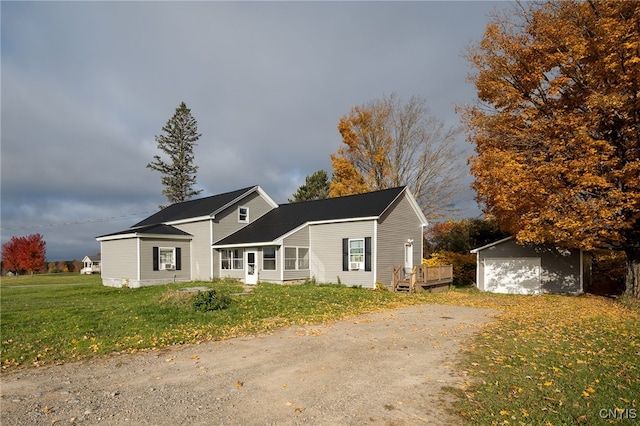 view of front facade featuring a garage, a front lawn, and an outdoor structure