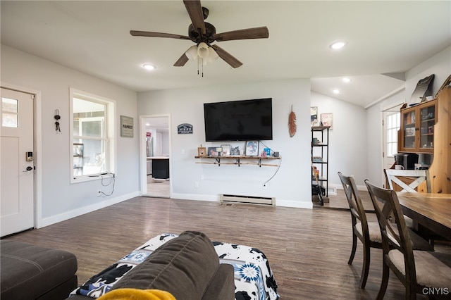 living room featuring lofted ceiling, baseboard heating, dark wood-type flooring, and ceiling fan