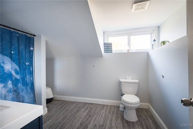 bathroom featuring toilet, lofted ceiling, hardwood / wood-style floors, and vanity