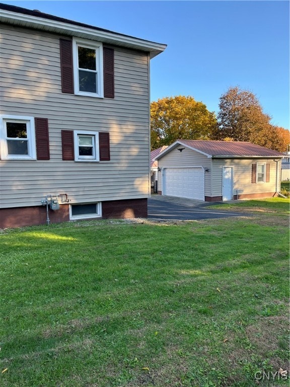 exterior space featuring an outbuilding, a yard, and a garage