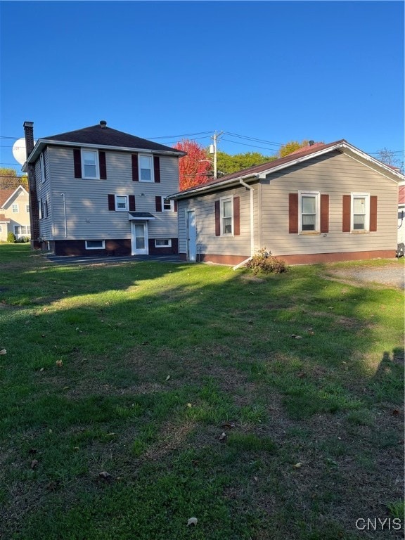 back of property featuring a lawn