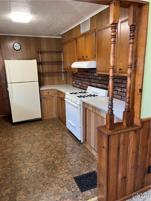 kitchen featuring white appliances and wood walls