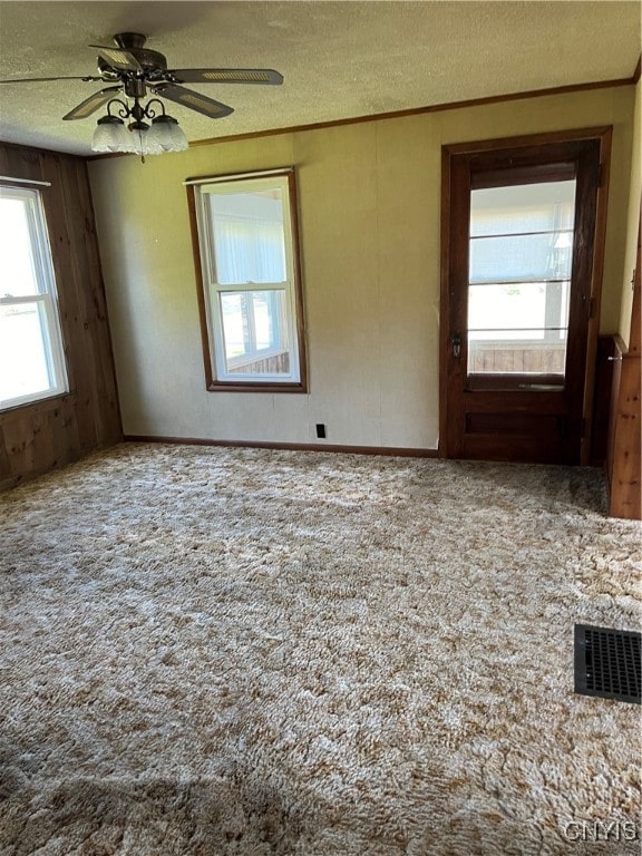 carpeted spare room with ceiling fan and a textured ceiling