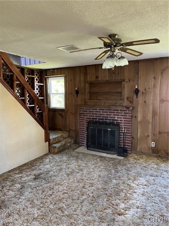 unfurnished living room with a fireplace, a textured ceiling, and carpet floors