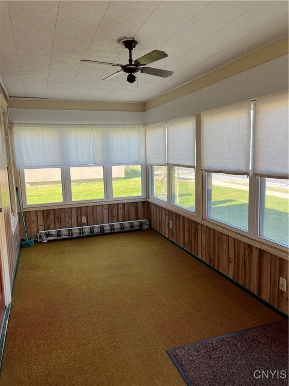 unfurnished sunroom with ceiling fan, a wealth of natural light, and baseboard heating