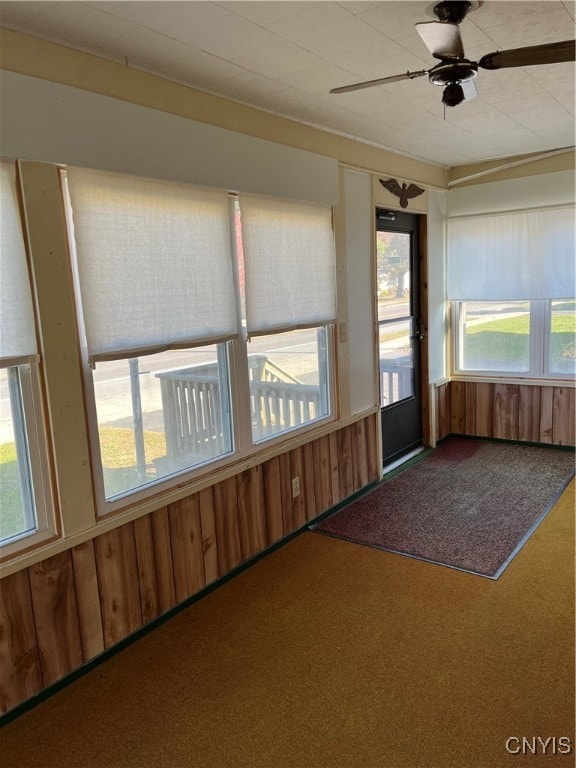 unfurnished sunroom with plenty of natural light and ceiling fan