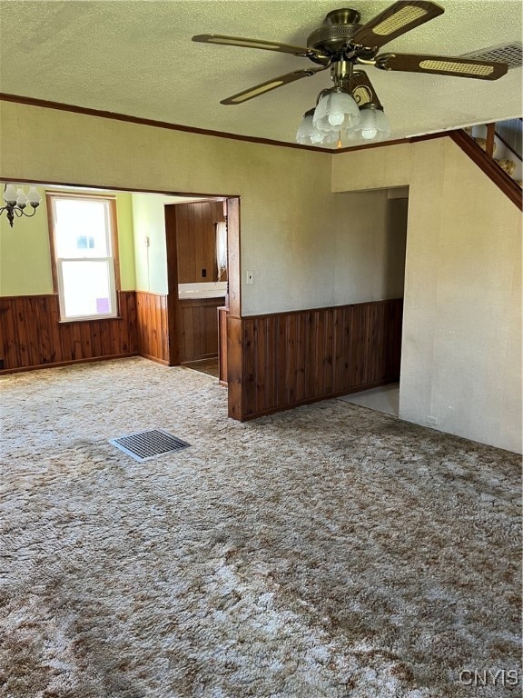 carpeted spare room with crown molding, a textured ceiling, and ceiling fan