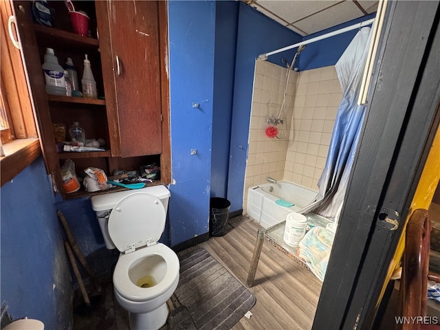 bathroom with toilet, shower / tub combo, a paneled ceiling, and hardwood / wood-style floors