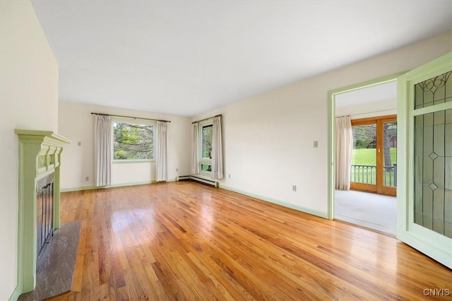 unfurnished living room featuring a baseboard radiator, a high end fireplace, and light wood-type flooring