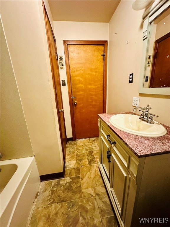 bathroom with vanity and a bath