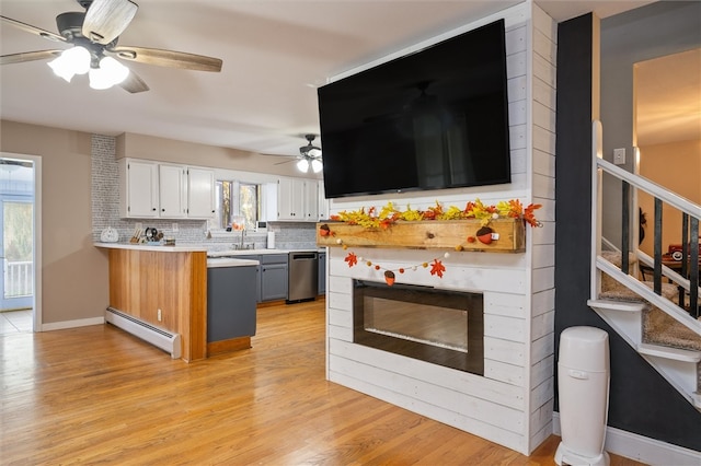 kitchen with a baseboard heating unit, ceiling fan, light hardwood / wood-style floors, white cabinets, and decorative backsplash