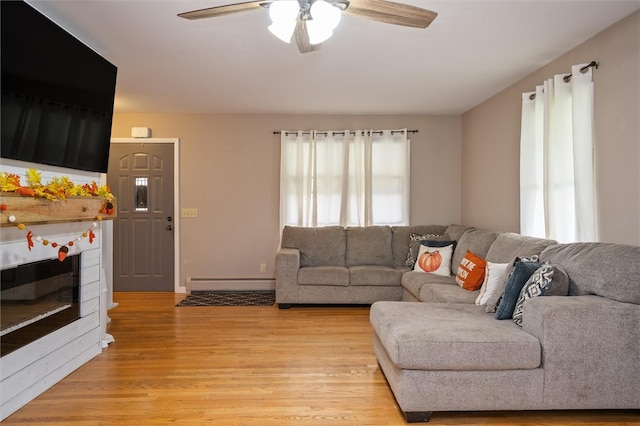 living room with light hardwood / wood-style floors, a baseboard radiator, and ceiling fan