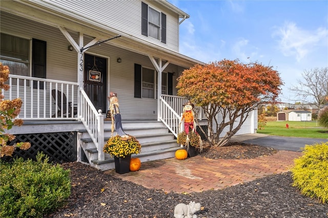 entrance to property with covered porch and a garage