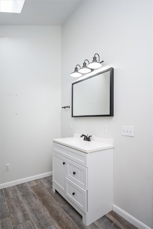 bathroom with vanity, hardwood / wood-style floors, and a skylight