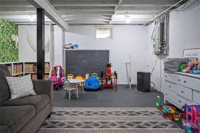 recreation room featuring electric panel and concrete flooring