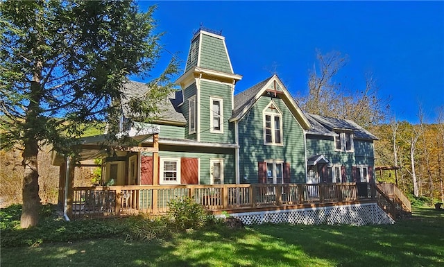 back of house featuring a deck and a lawn