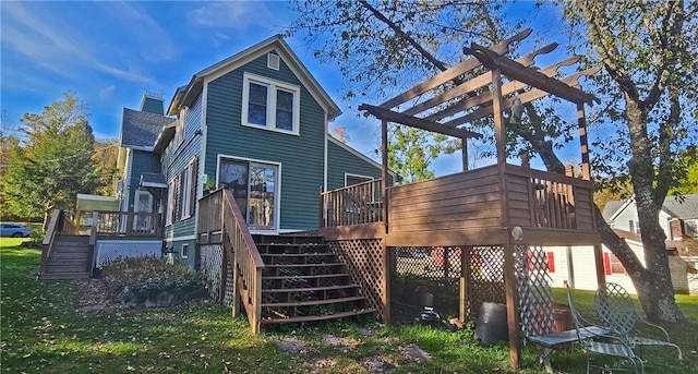 back of house with a wooden deck, a pergola, and a lawn